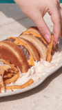 Pão de Hambúrguer sem glúten Di Mangiare – mão segurando pedaço de pão junto à travessa