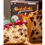 Chocotone sem glúten e sem leite Di Mangiare, 500 g – Detalhe do miolo de chocotone com pedaços de chocolate, ao lado de uma fatia e da caixa ao fundo